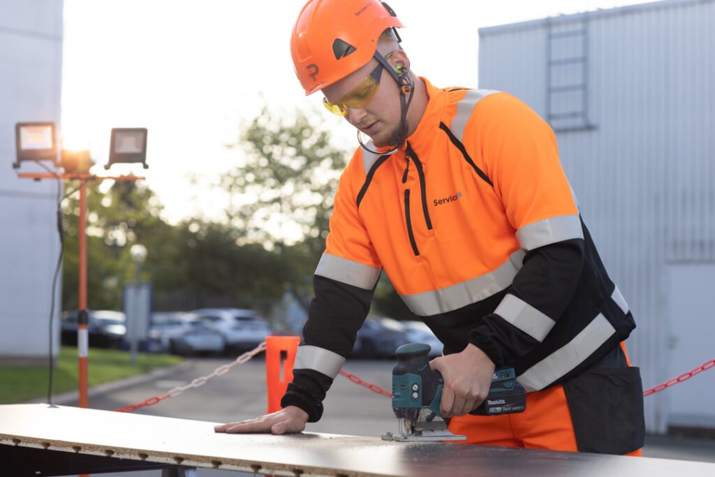 Tagdækker skærer tagplade til på byggeplads – del af opgave med tilbud på nyt tag.