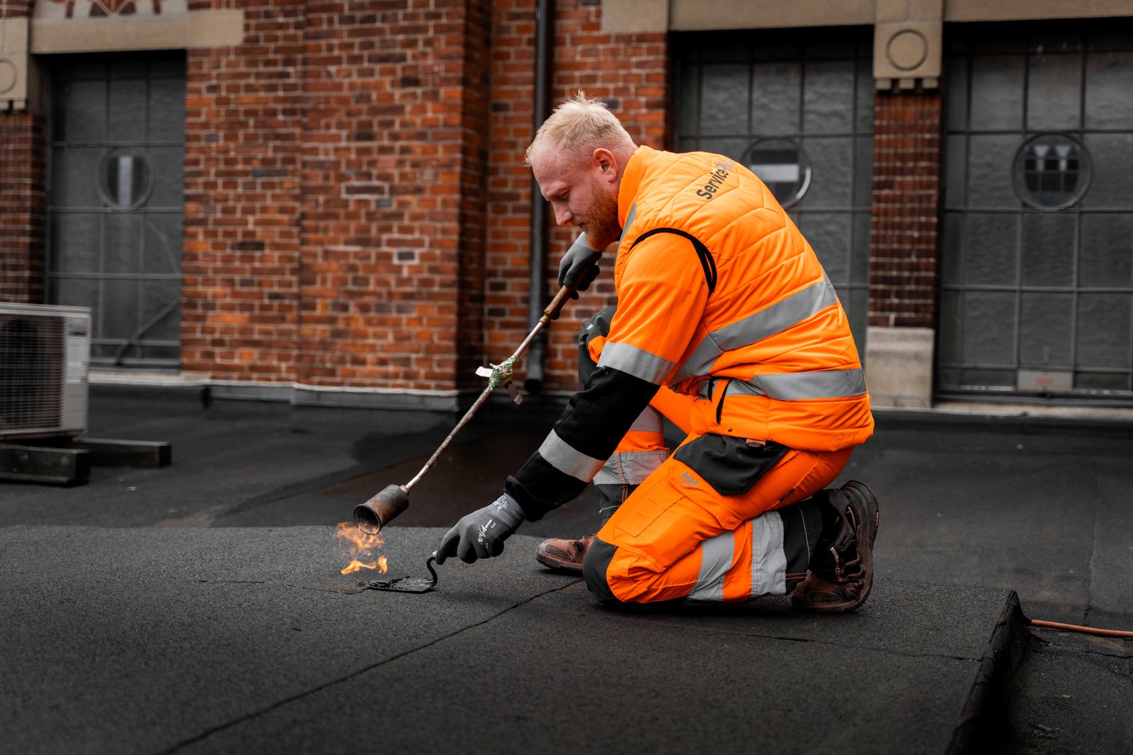 Fire tagdækkere i arbejdstøj og hjelme står klar til opgave – relevant billede til “tilbud nyt tag”.